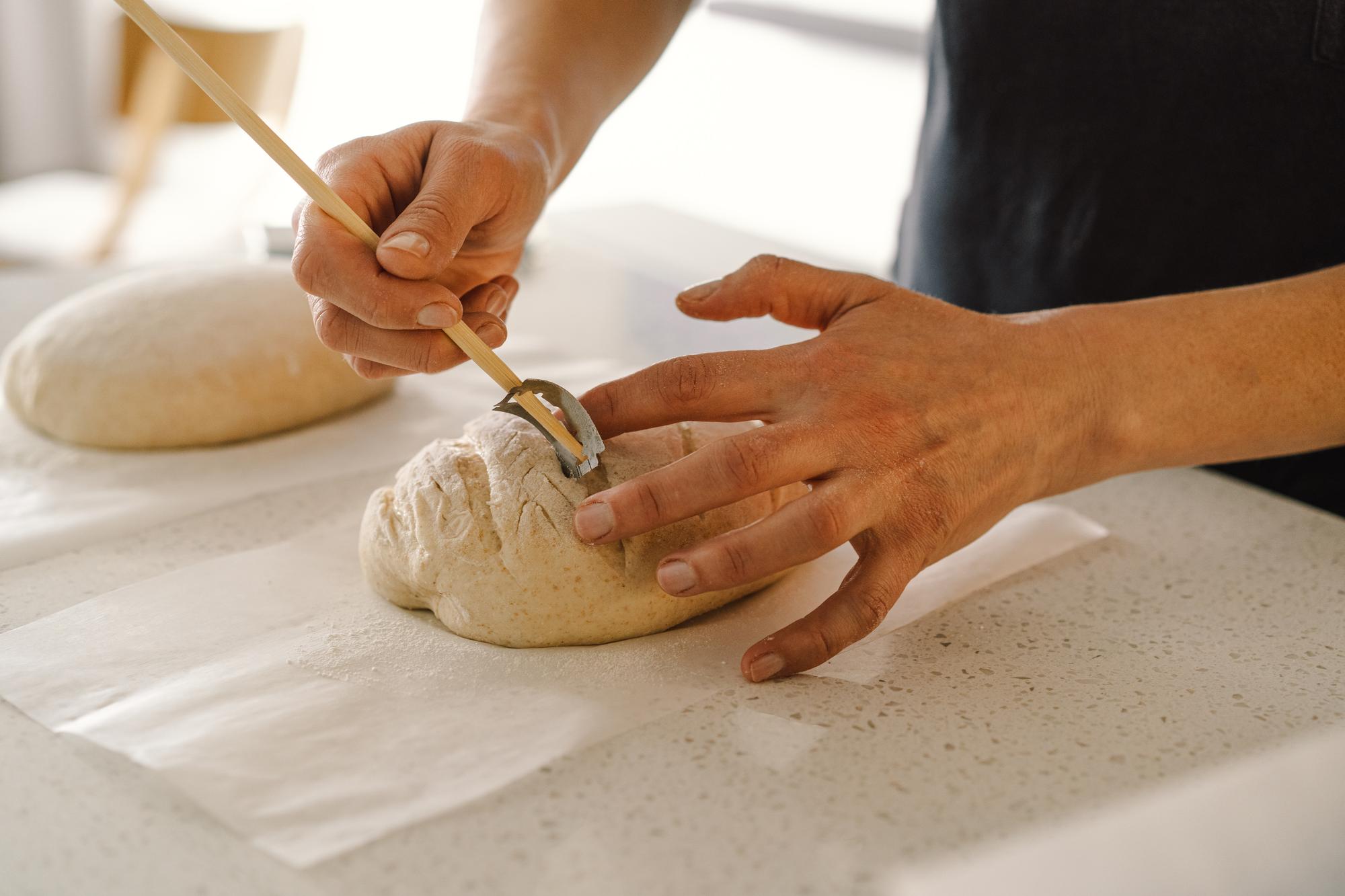 Dettaglio di mani che impastano pane