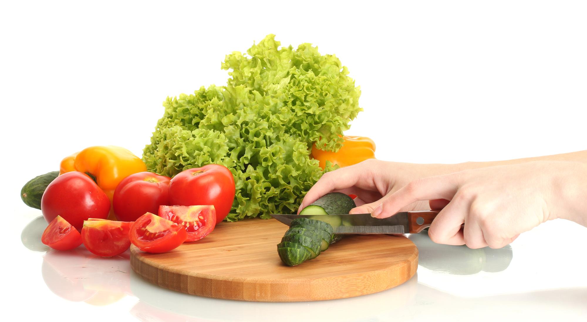 Dettaglio mani che tagliano verdure fresche