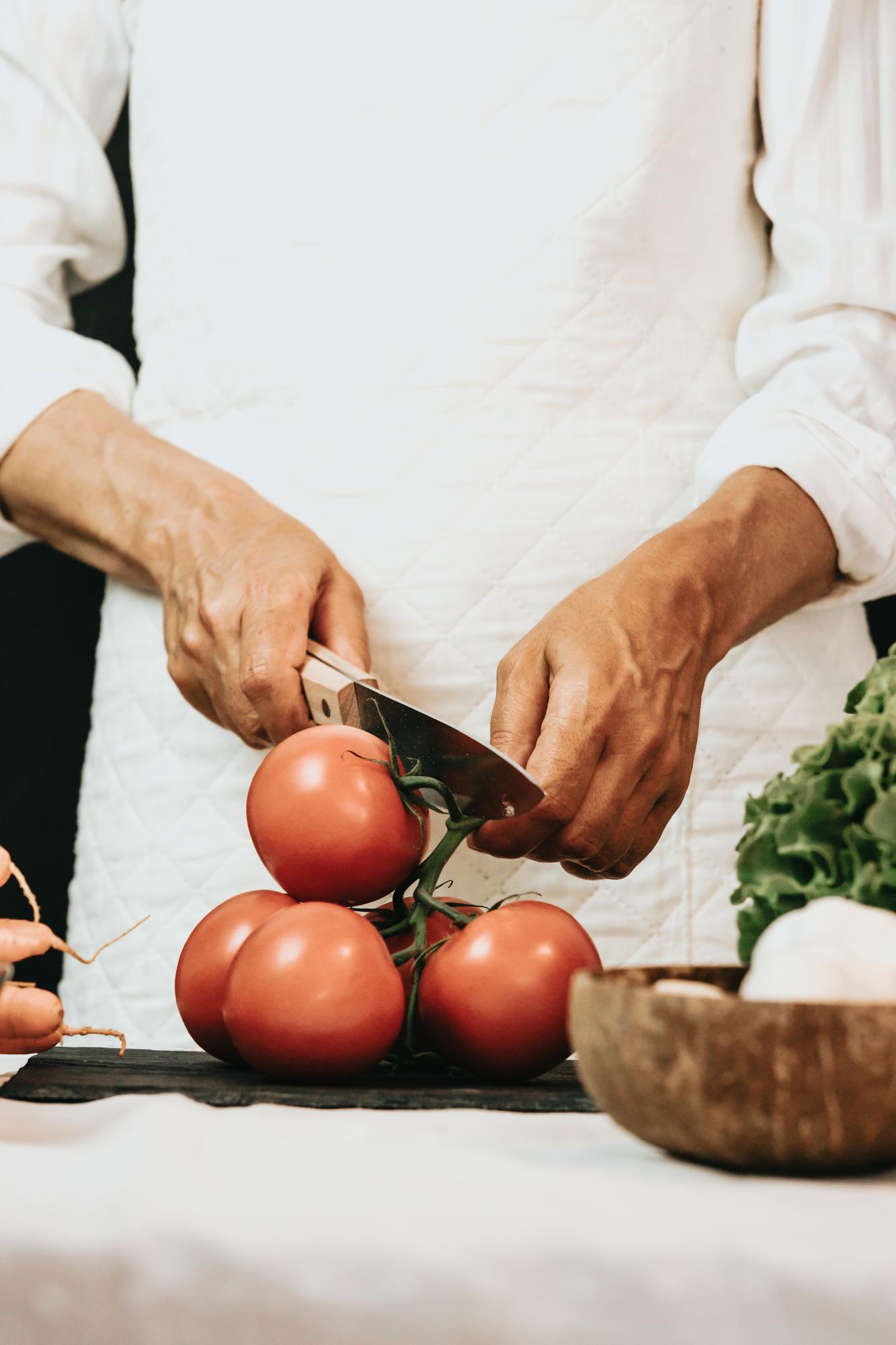 Chef al lavoro su tavolo rustico con ingredienti